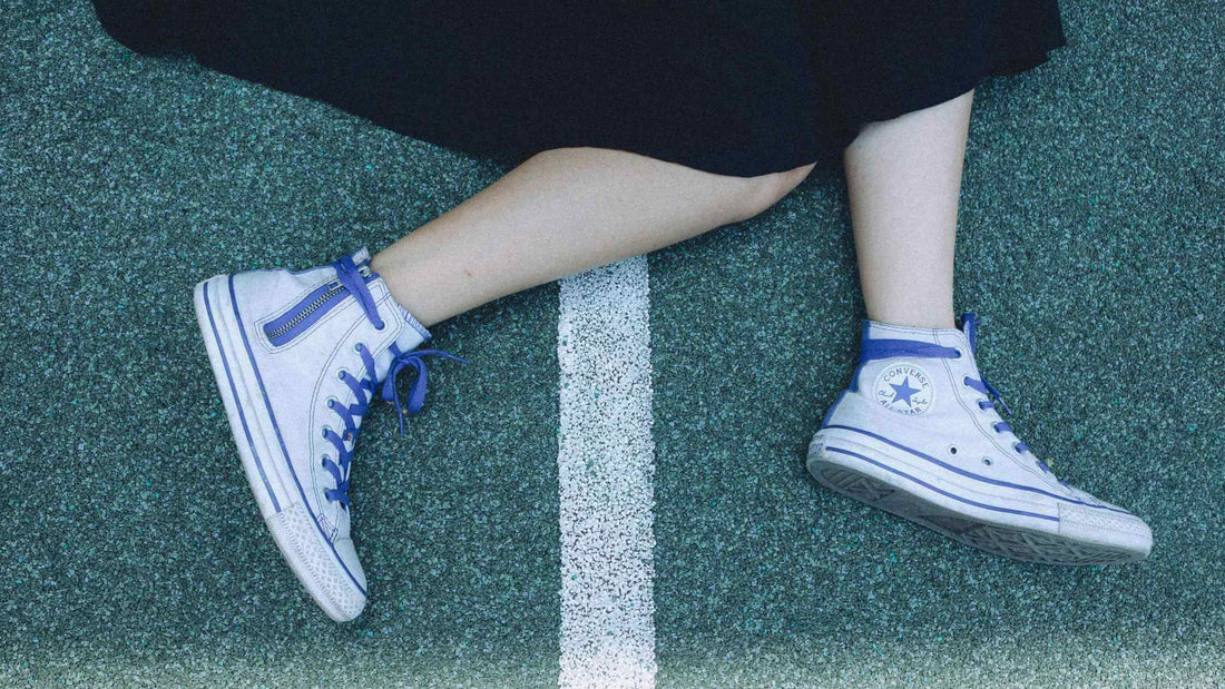 Converse all star trainers paired with a skirt at Brag vintage